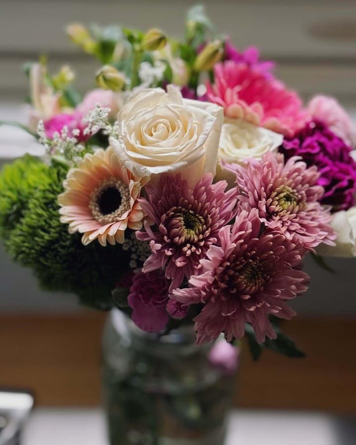 A pink and white flower bouquet in a vase.
