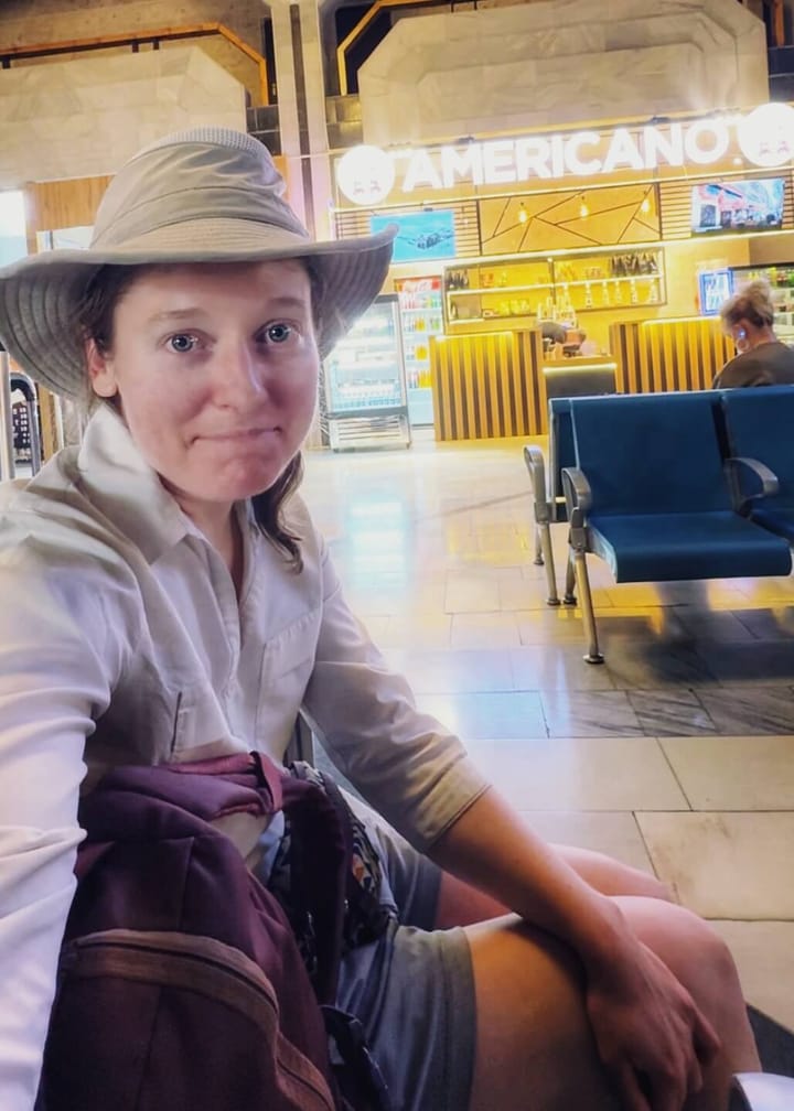 Clara Ritger grimaces in front of a coffee shop called, "Americano."